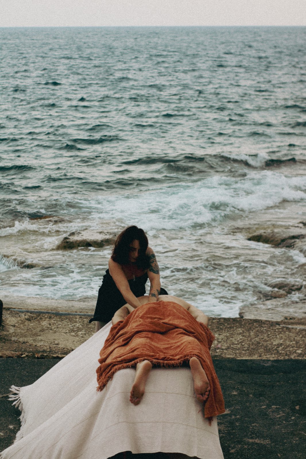 Julie giving a massage on a table set by the Mediterranean sea
